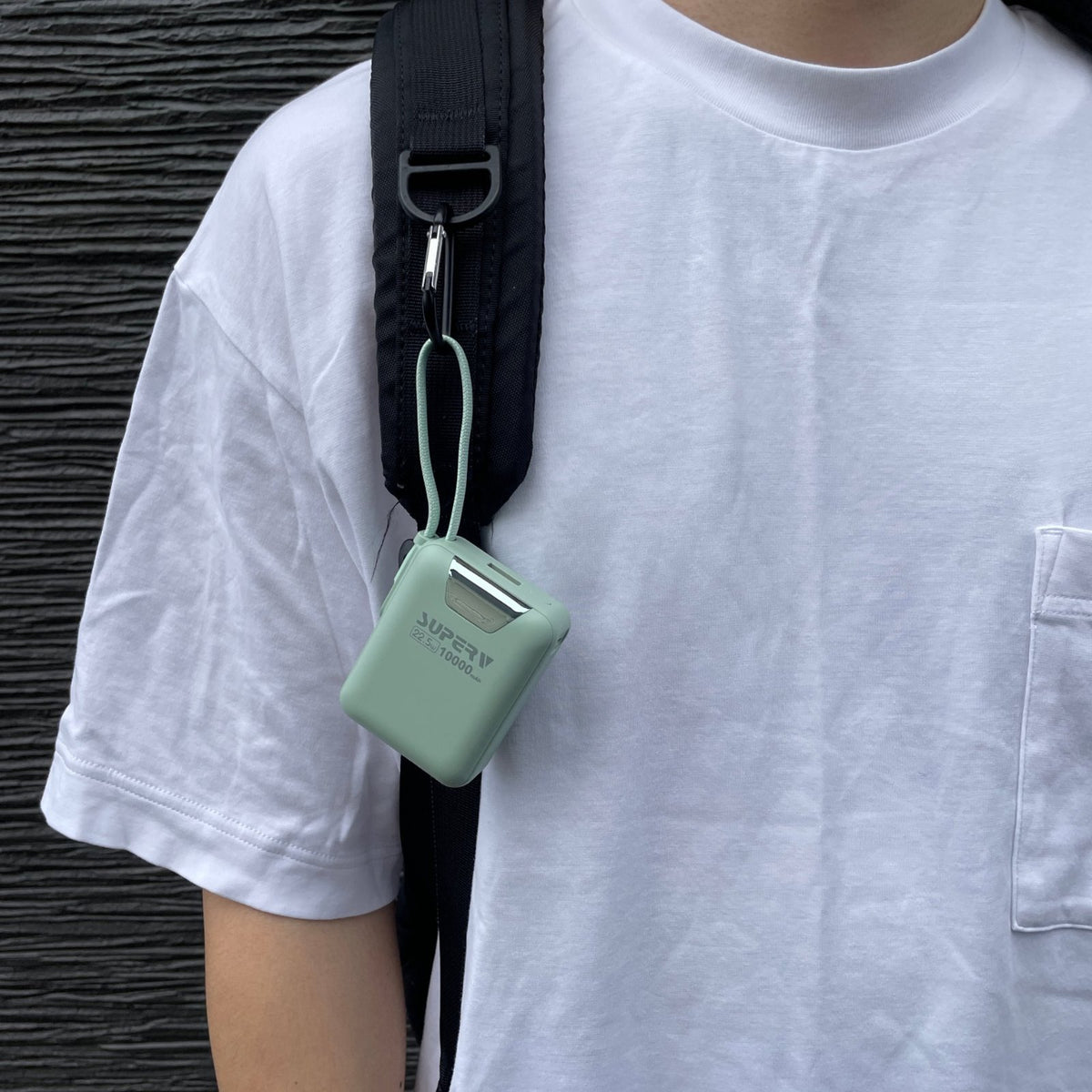 Power15 グリーンをリュックの肩ベルトに吊るした着用イメージ｜ケーブルがそのままストラップになるモバイルバッテリー